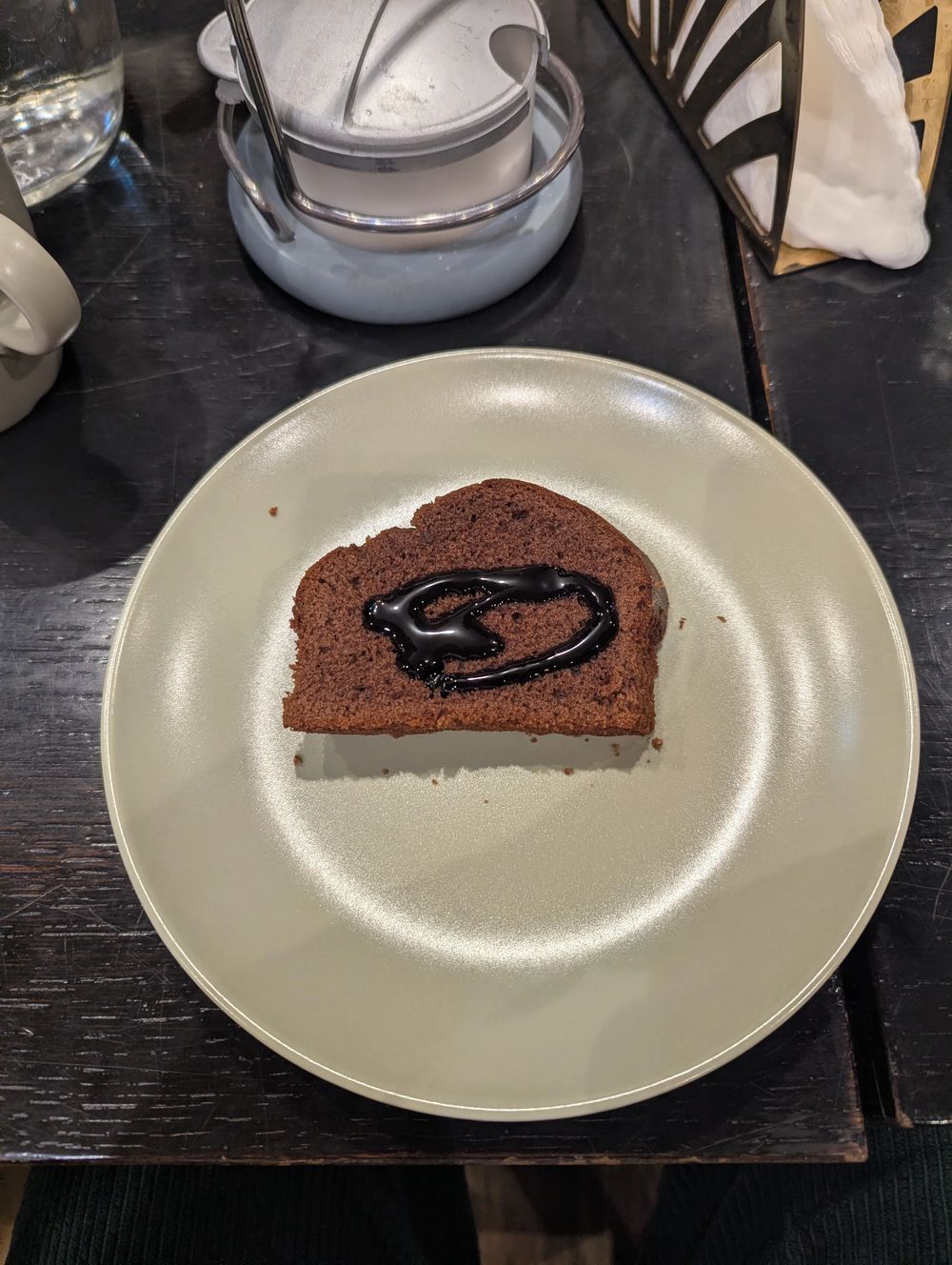 Une part de gâteau au chocolat nappée de coulis sur une assiette.