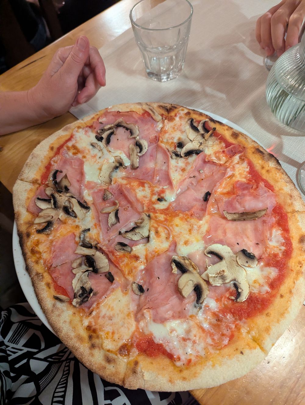 Grande pizza fine à la sauce tomate, mozzarella, jambon et champignons.