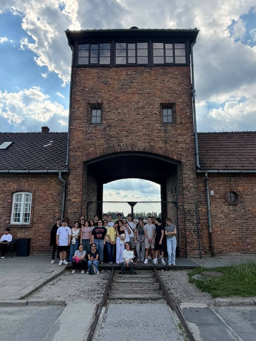 Photo de groupe du voyage sous la tour-porte de Birkenau, au-dessus de la voie ferrée.