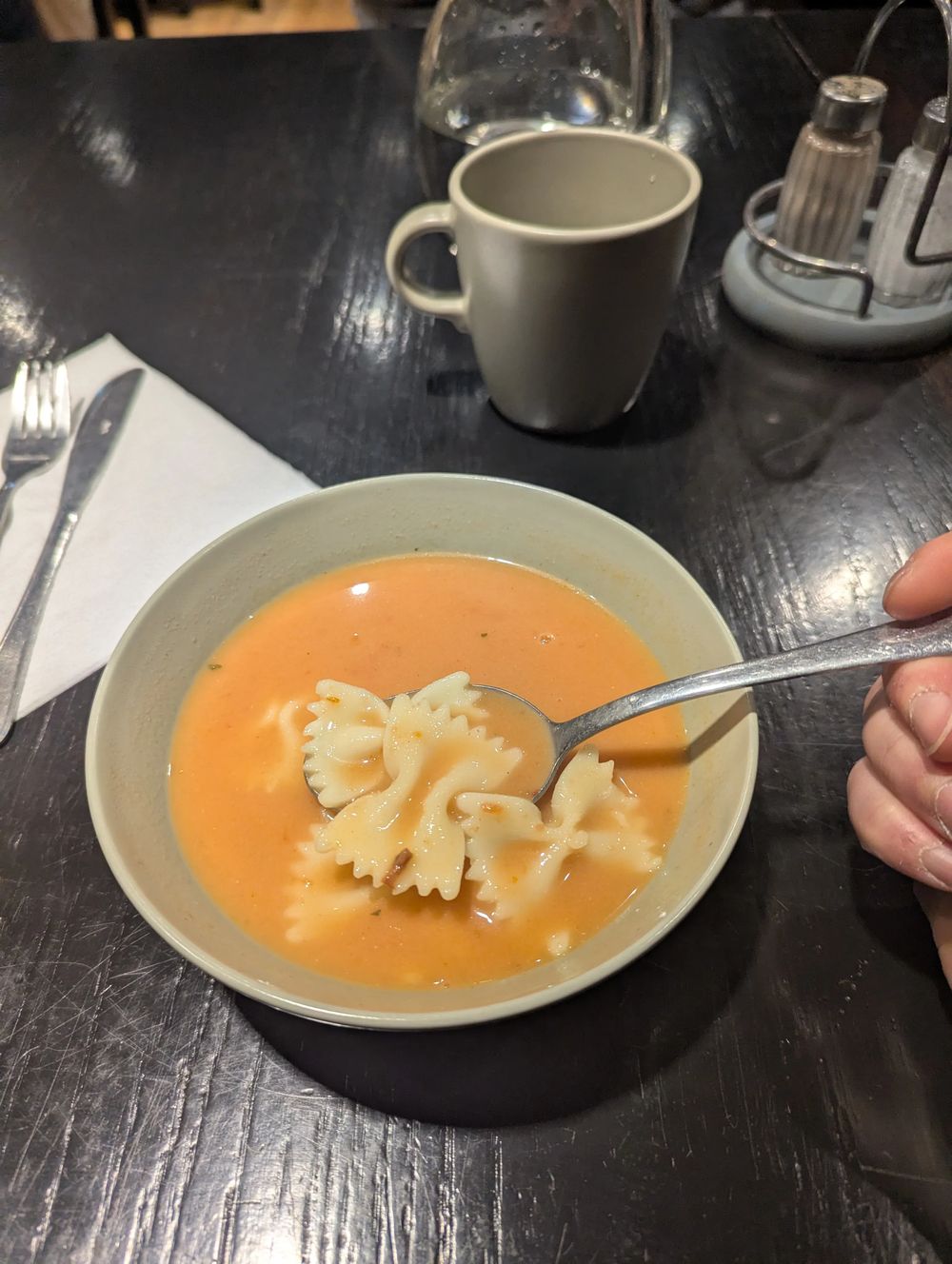 Un bol de soupe crémeuse à la tomate avec des pâtes papillon.