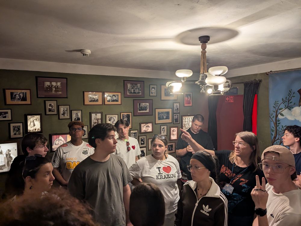 Une salle aux murs couverts de portraits anciens, évoquant la vie quotidienne d'avant-guerre.