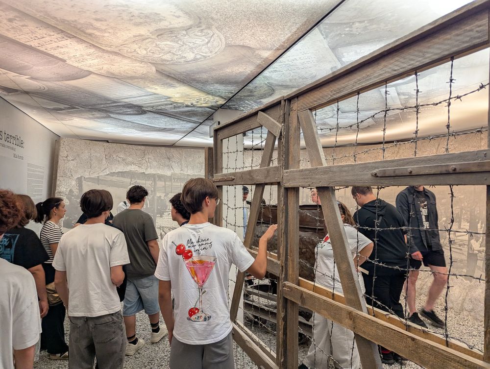 Une installation du parcours, entre barbelés et images d'archives, évoquant l'enfermement.