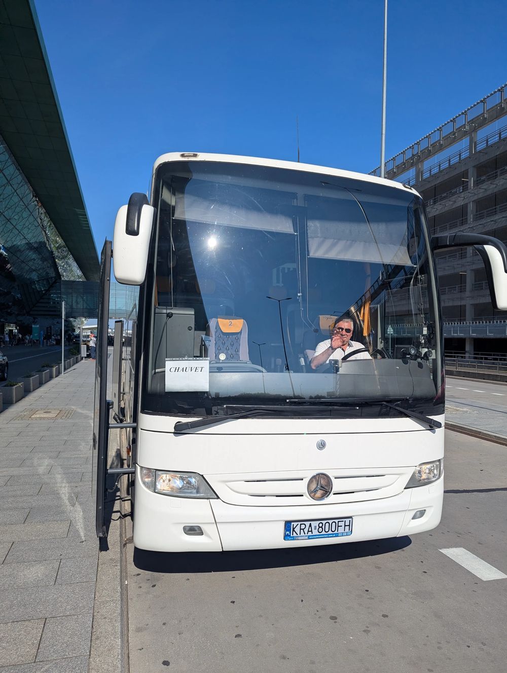 Devant l'aérogare, notre chauffeur salue une dernière fois depuis son autocar avant le départ.